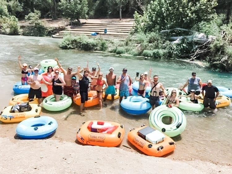 Large group enjoying a river tubing trip with Red Star party bus transportation in Central Texas